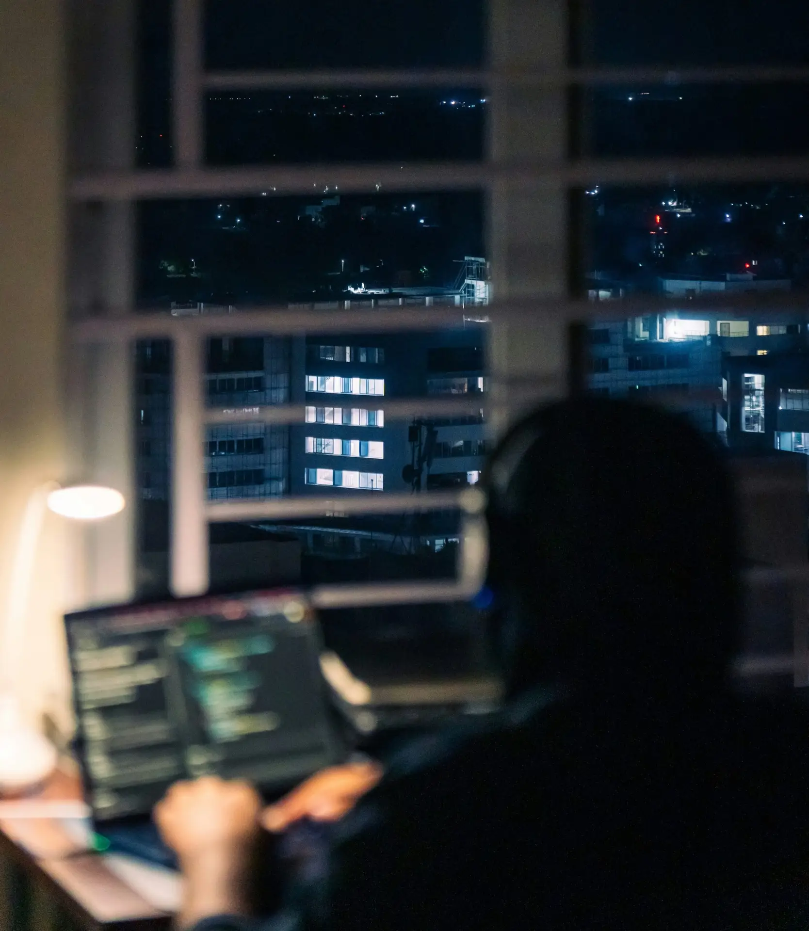 IT professional working remotely on a laptop at night