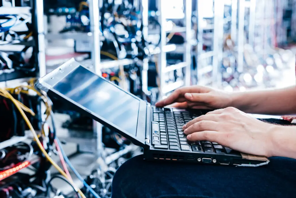 Technician using a laptop to manage computer systems