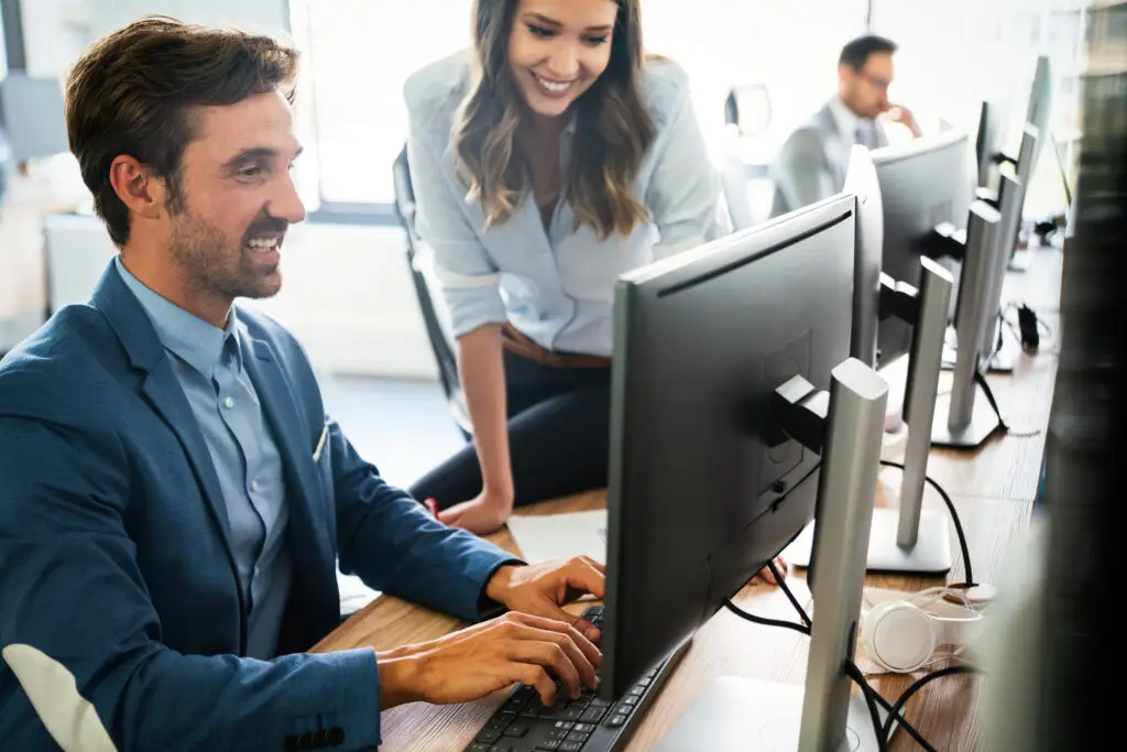 IT professionals working together at office computers