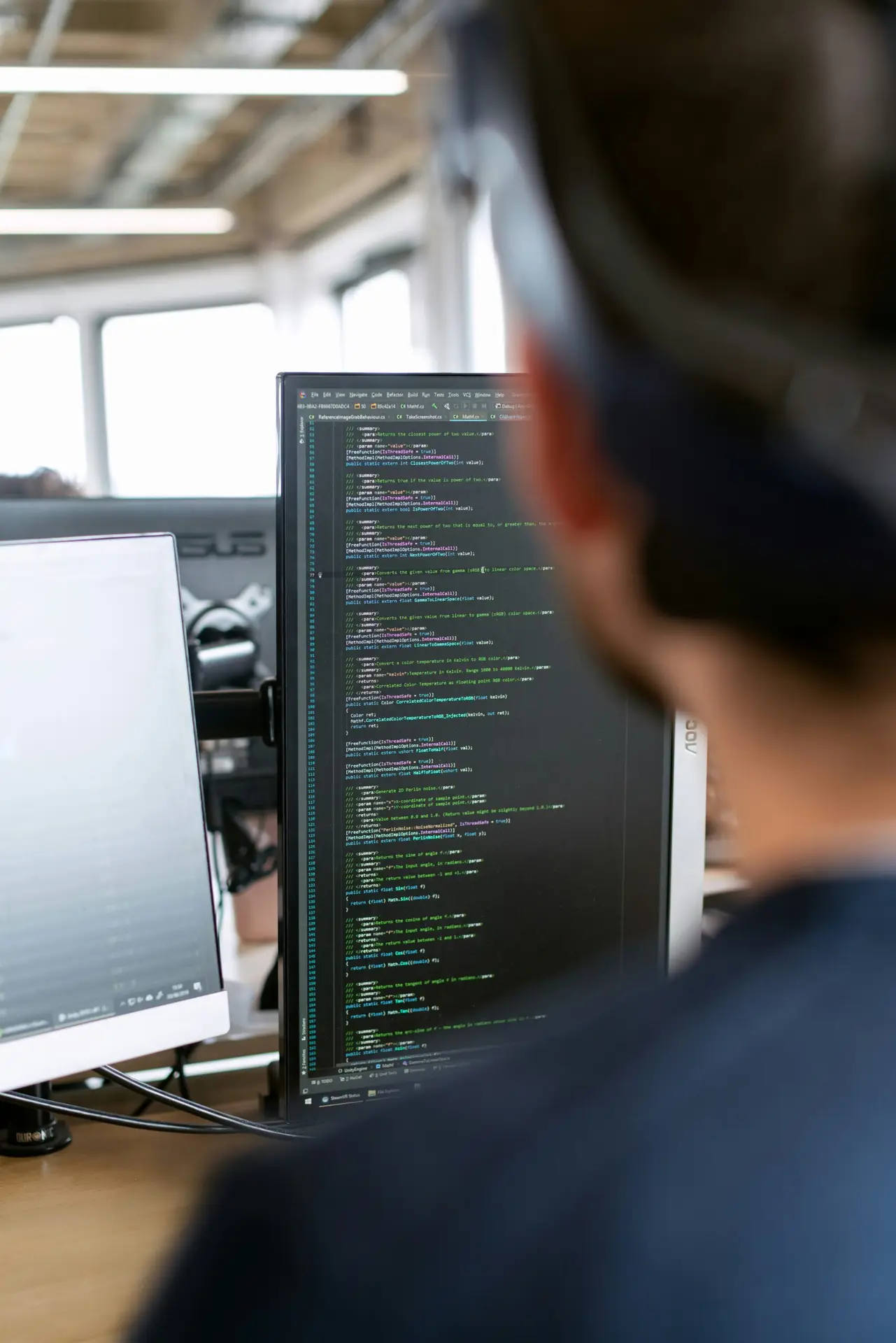 IT specialist reviewing computer code on a monitor
