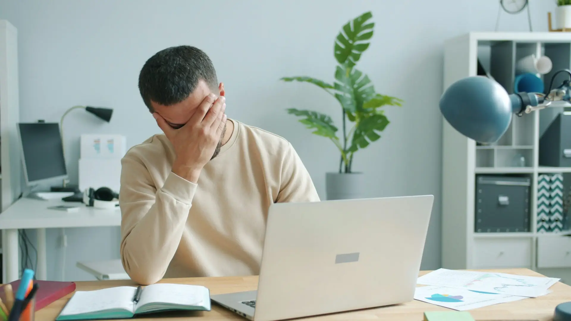 Frustrated man experiencing laptop computer problems at his desk